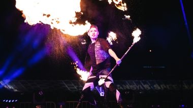 Man spinning sticks that are on fire