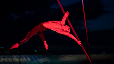 Man hanging upside down from a hanging pole